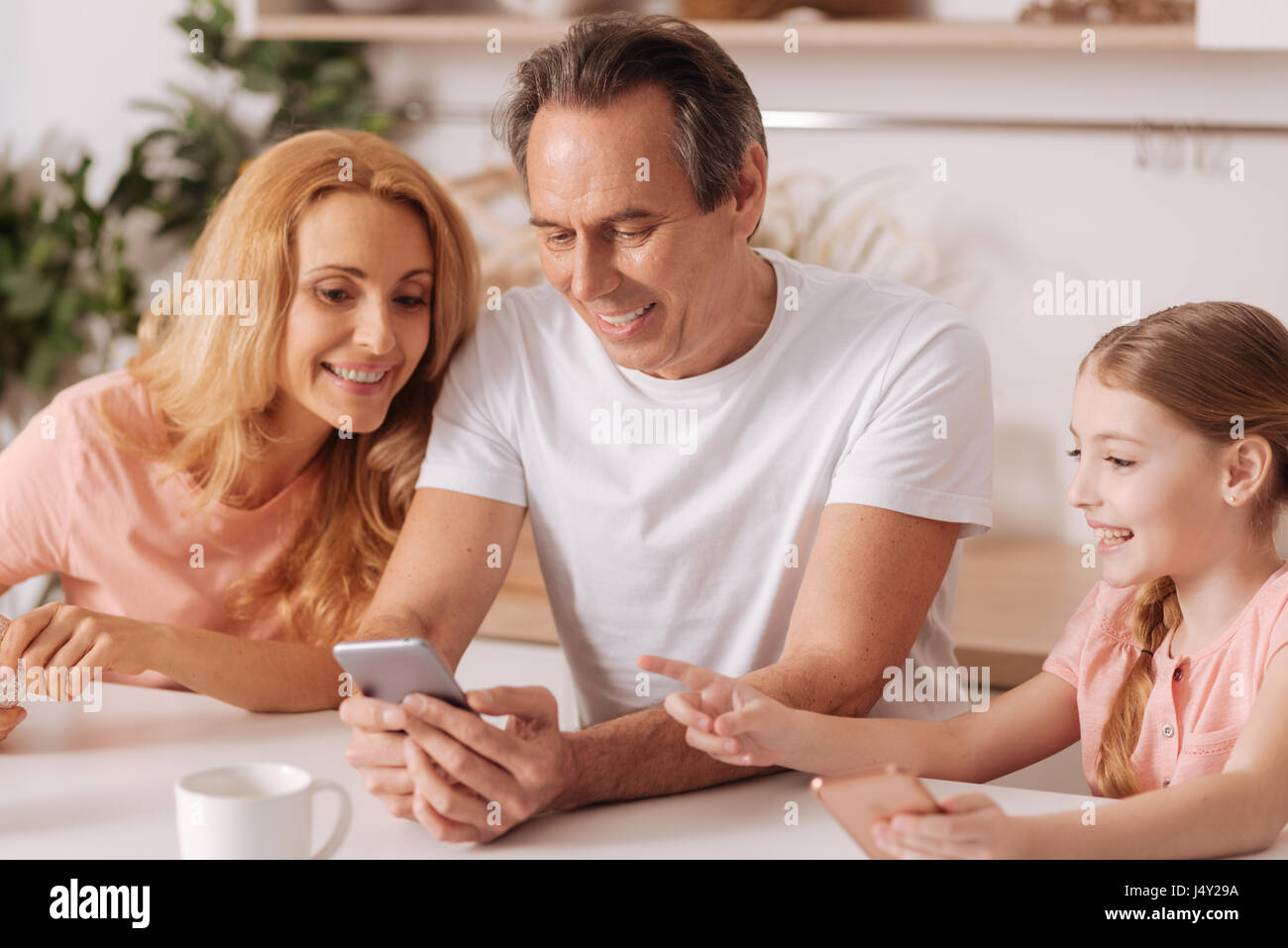 La famiglia felice utilizzando gadget elettronici e navigare in Internet in ambienti interni Foto Stock