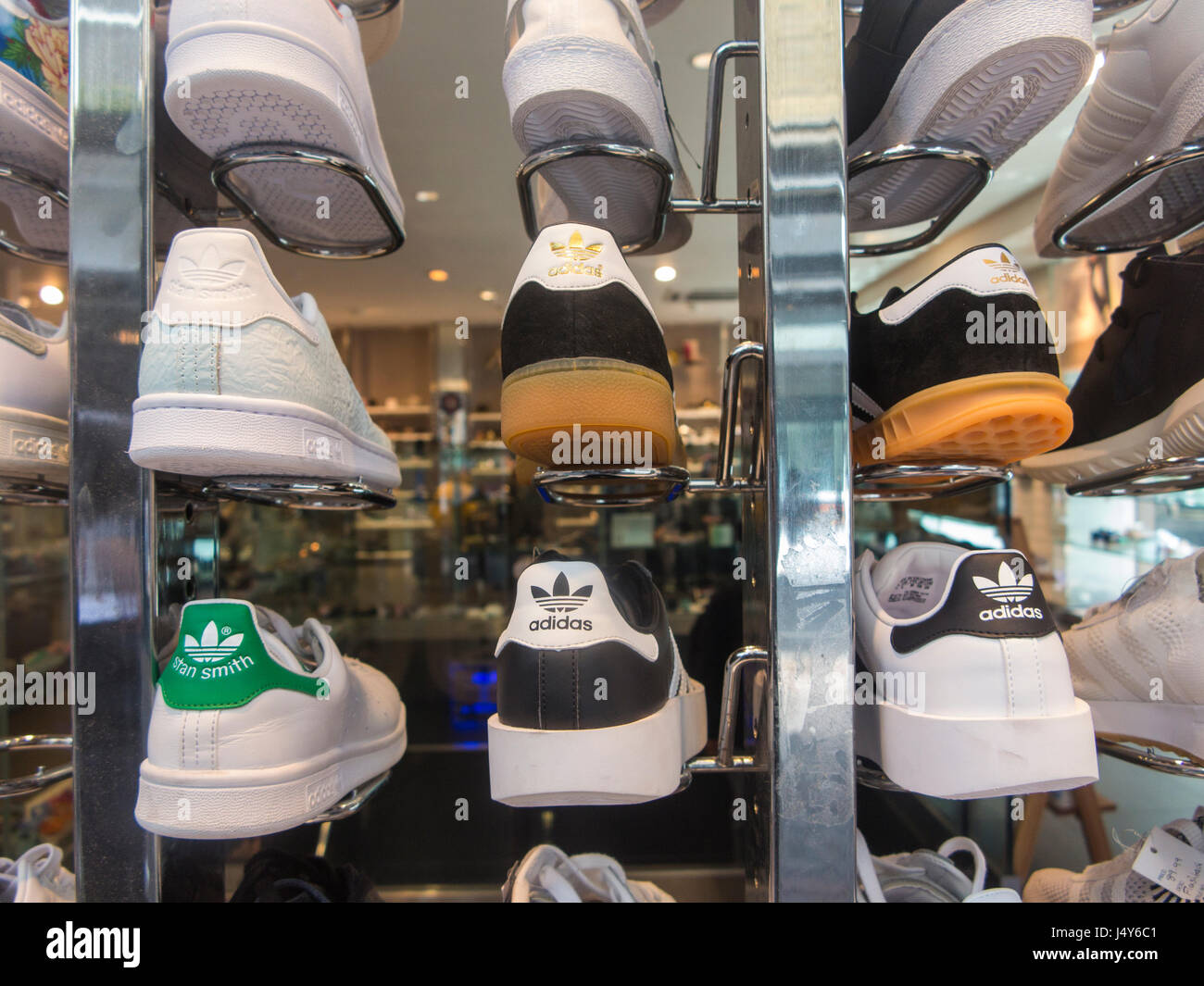 Con il marchio Adidas e Nike trainer in un negozio di scarpe di Soho, Londra Foto Stock