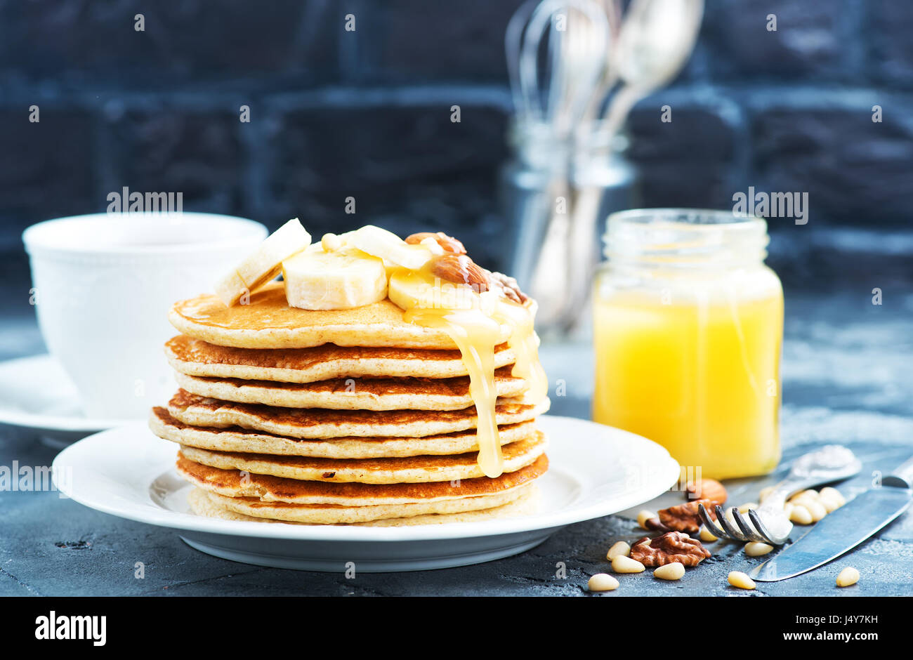 Frittelle con il miele e i dadi sulla piastra Foto Stock