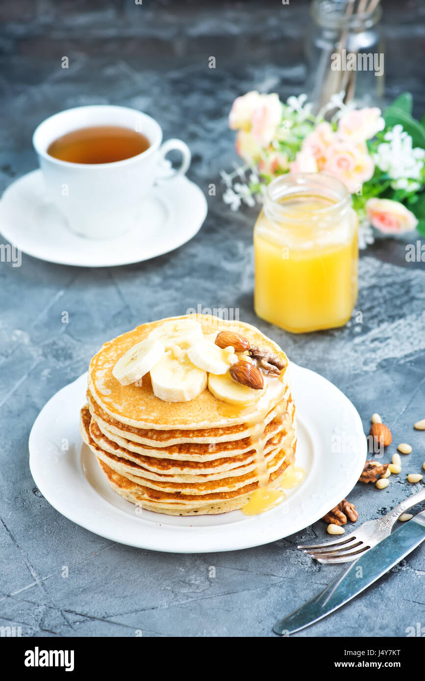 Frittelle con il miele e i dadi sulla piastra Foto Stock