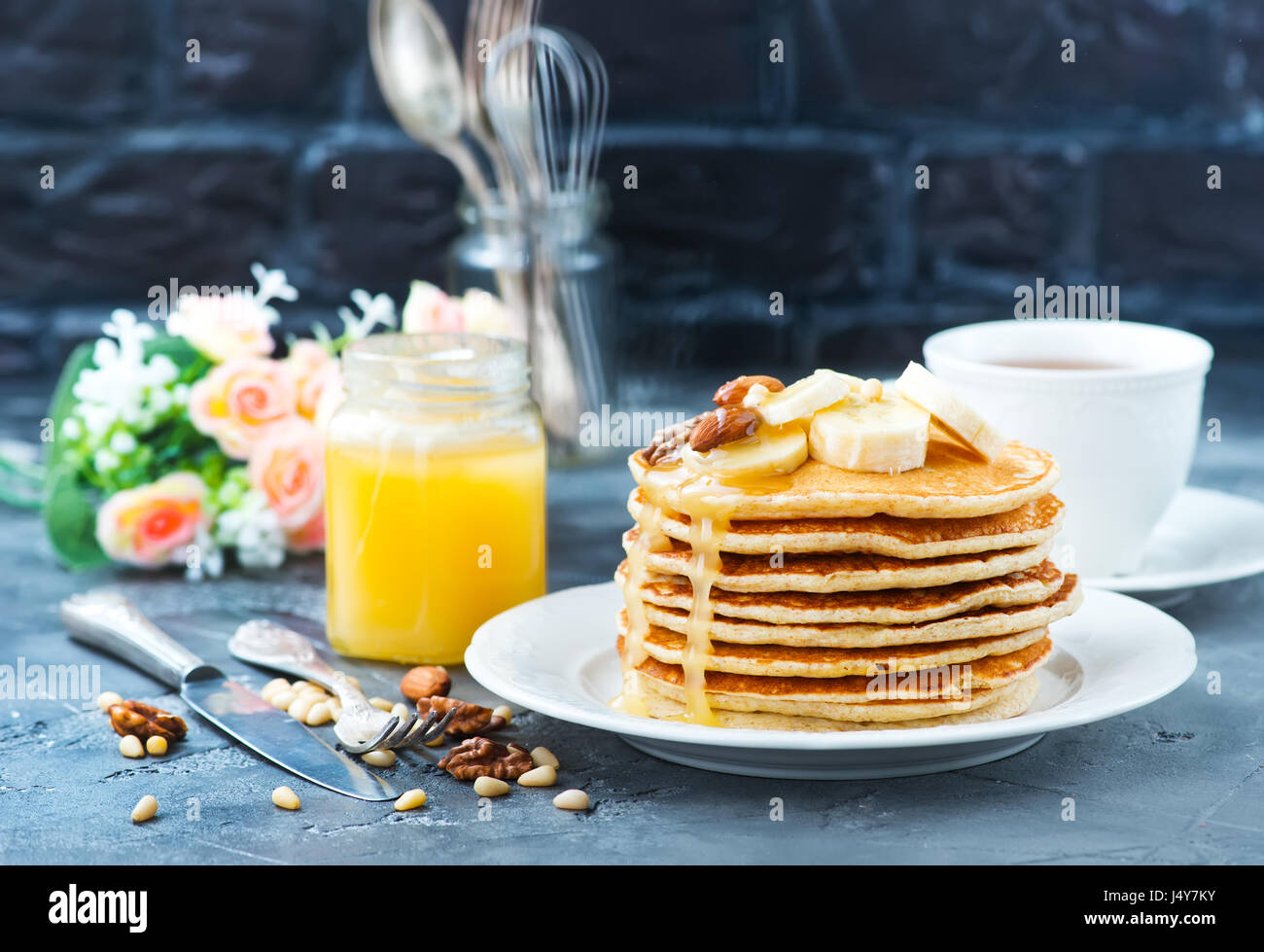 Frittelle con il miele e i dadi sulla piastra Foto Stock