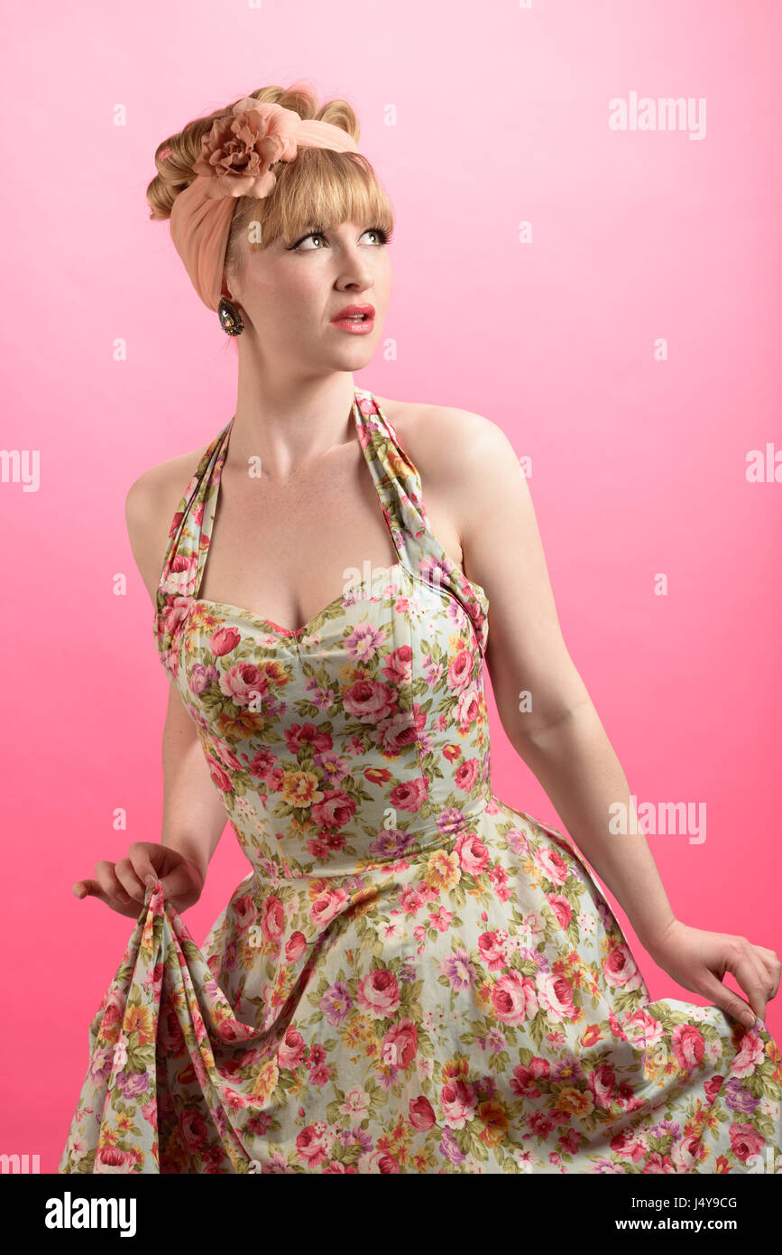 Lo stile pin up shot della donna che indossa in stile vintage abbigliamento  su uno sfondo rosa Foto stock - Alamy