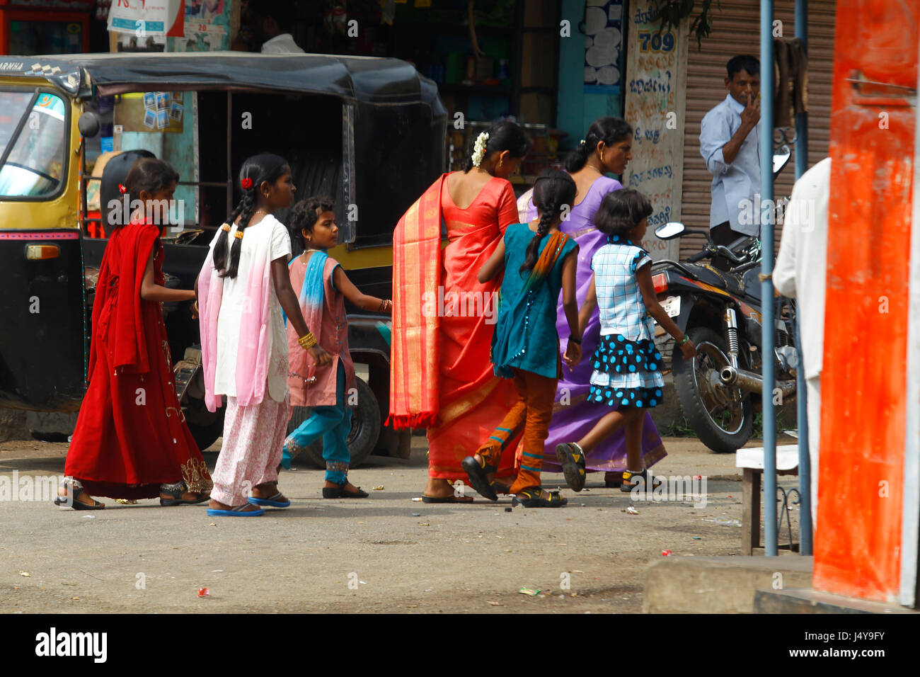 Famiglia indiana nei tradizionali abiti colorati camminare per le strade, Karnataka, India Foto Stock