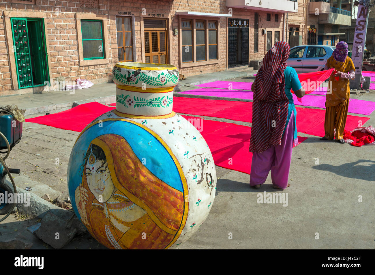 Le donne l'asciugatura del tessuto colorato su un marciapiede in Jodhpur, India Foto Stock