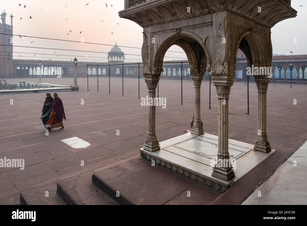 Delhi, India - 11 Novemver 2012 - Le donne a piedi nel cortile a Jama Masjid moschea di mattina presto la luce in Delhi Foto Stock