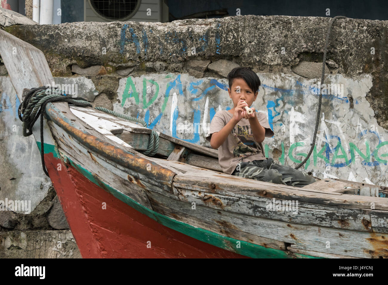 Il ragazzo con il flauto, Sunda Kelapa Inner Harbour, Jakarta, Indonesia Foto Stock