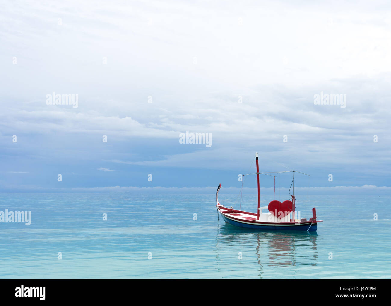 Barca con cuore rosso nell'oceano Foto Stock