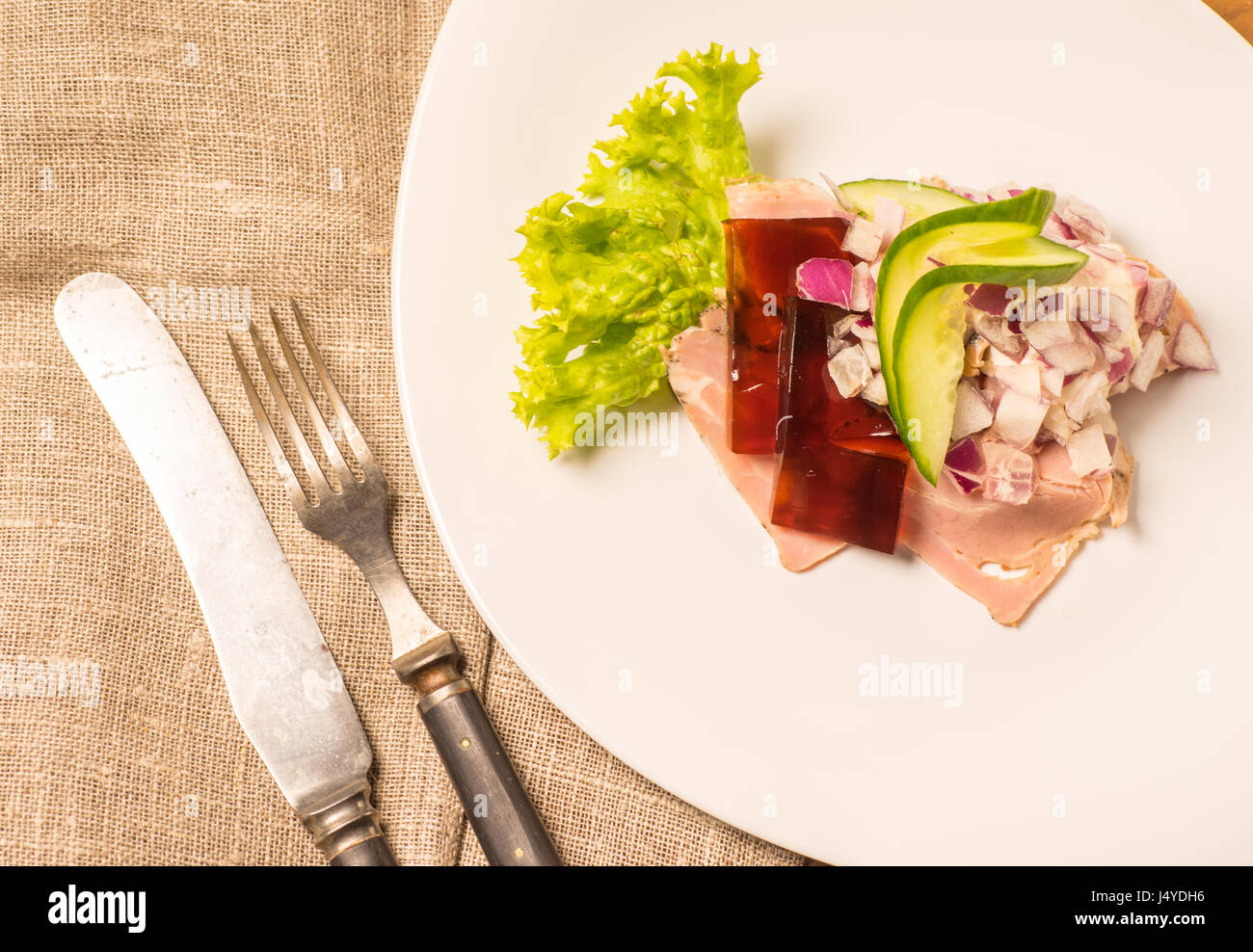 Specialità danesi e piatti nazionali e di alta qualità di sandwich aperto. Sandwich con rotolo di maiale salsiccia, rullepoelse, , jelly e materie cipolle rosse servite o Foto Stock