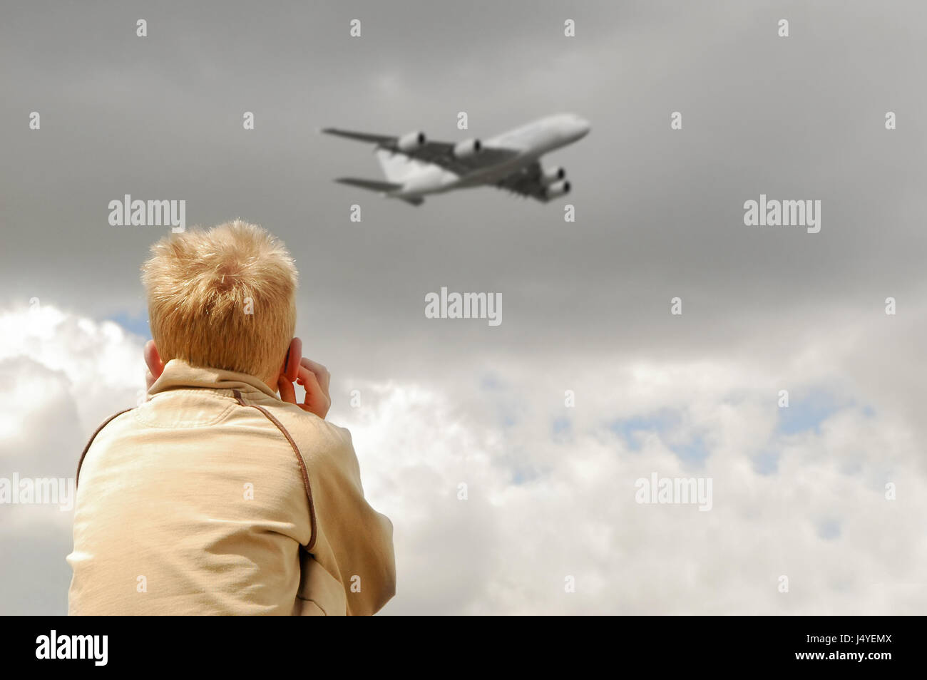 Bambino piccolo deafened dal fragore di grandi aviogetti tettuccio Foto Stock