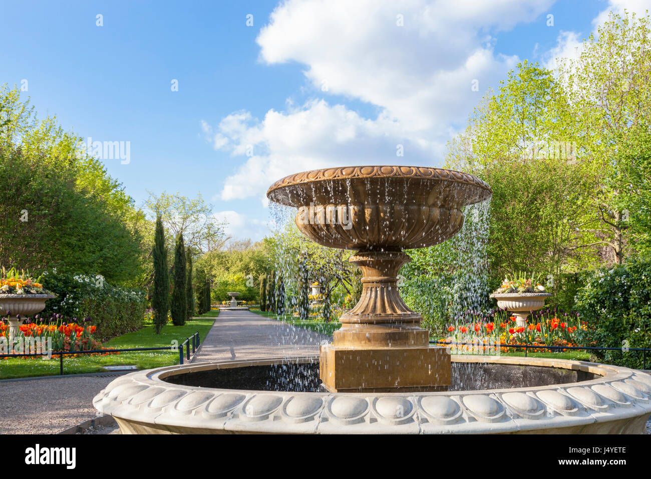 Alberi, fiori e una fontana in Avenue Giardini a Regents Park, Londra, uno dei parchi reali. London, England, Regno Unito Foto Stock