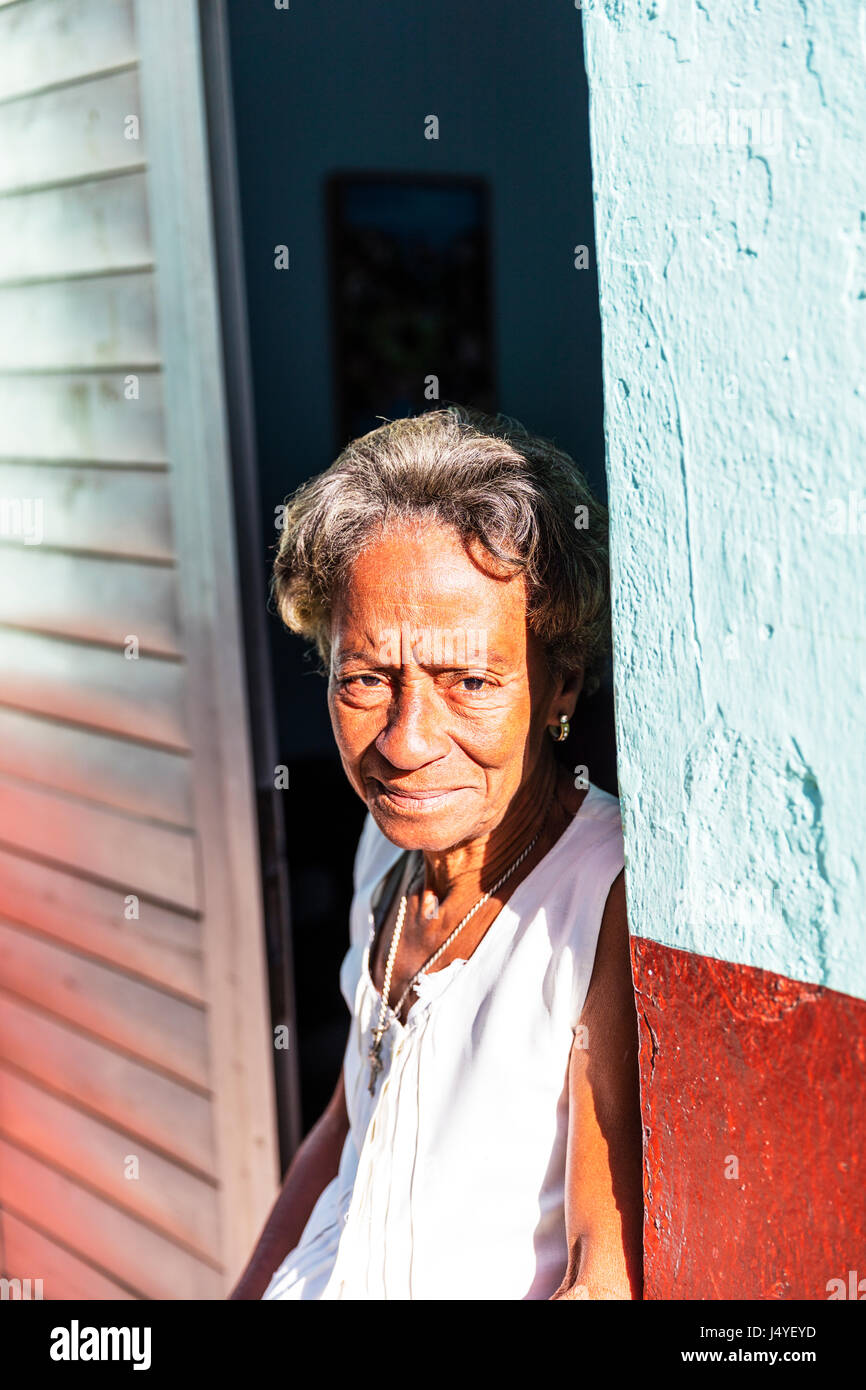 Vecchia Signora cubana in porta, guardando triste, povertà cubano, Afro-cubano donna lady, old Lady in Cuba Foto Stock