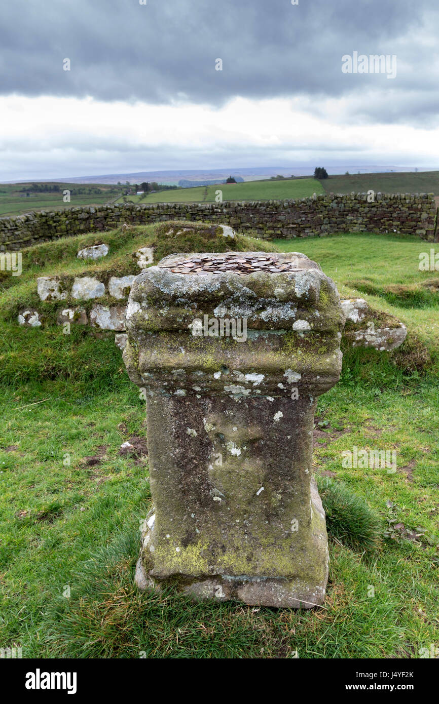Altare di pietra con il giorno moderno offerte votive, Aesica Roman Fort (grande Chesters) del Vallo di Adriano, Haltwhistle, Northumberland, Regno Unito Foto Stock
