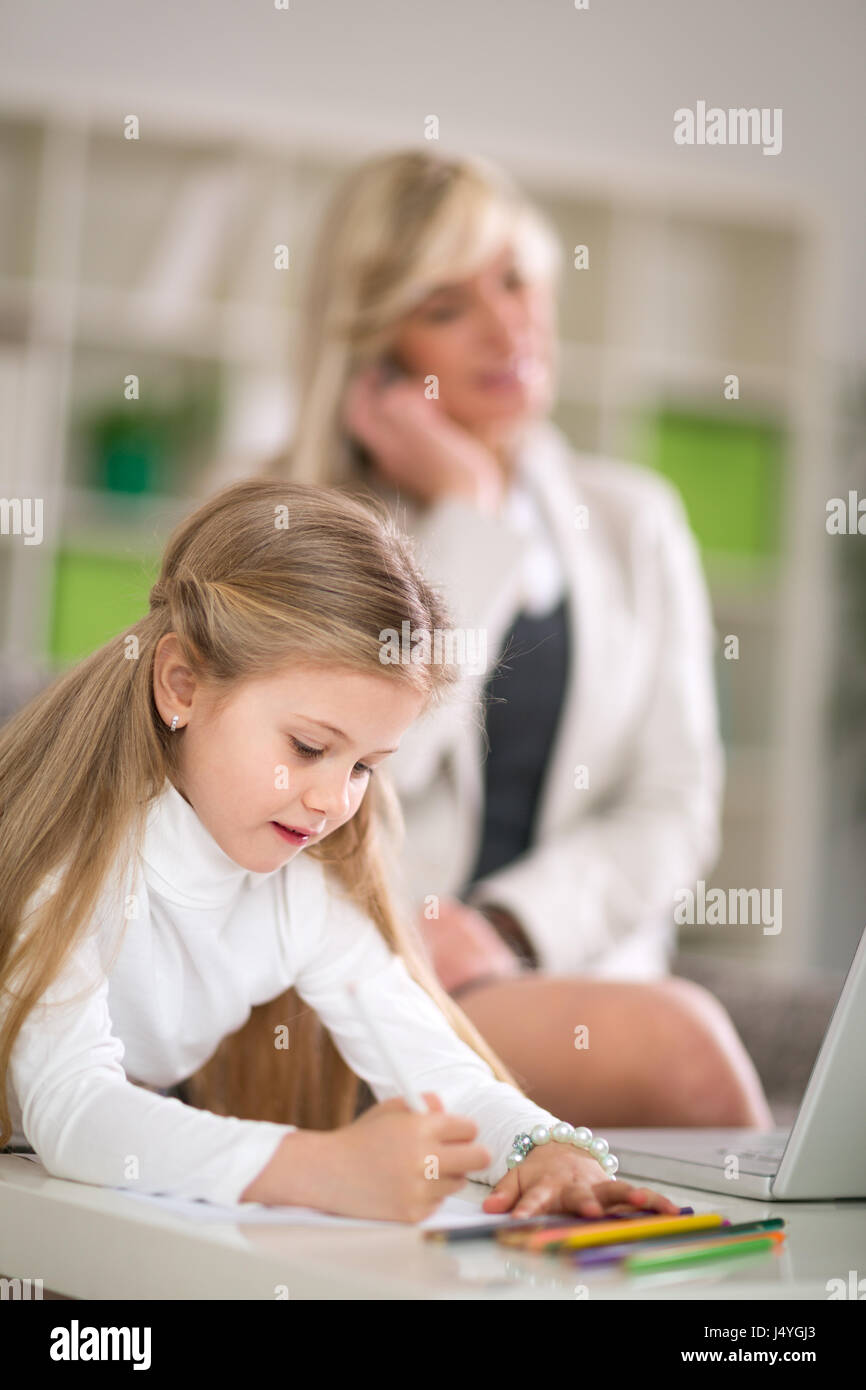 Italian studiare mentre la madre lavora a casa Foto Stock