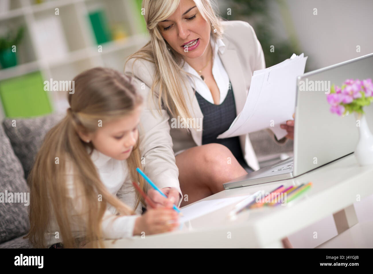 Figlia di fare i compiti con la mamma help, il concetto di istruzione a casa Foto Stock