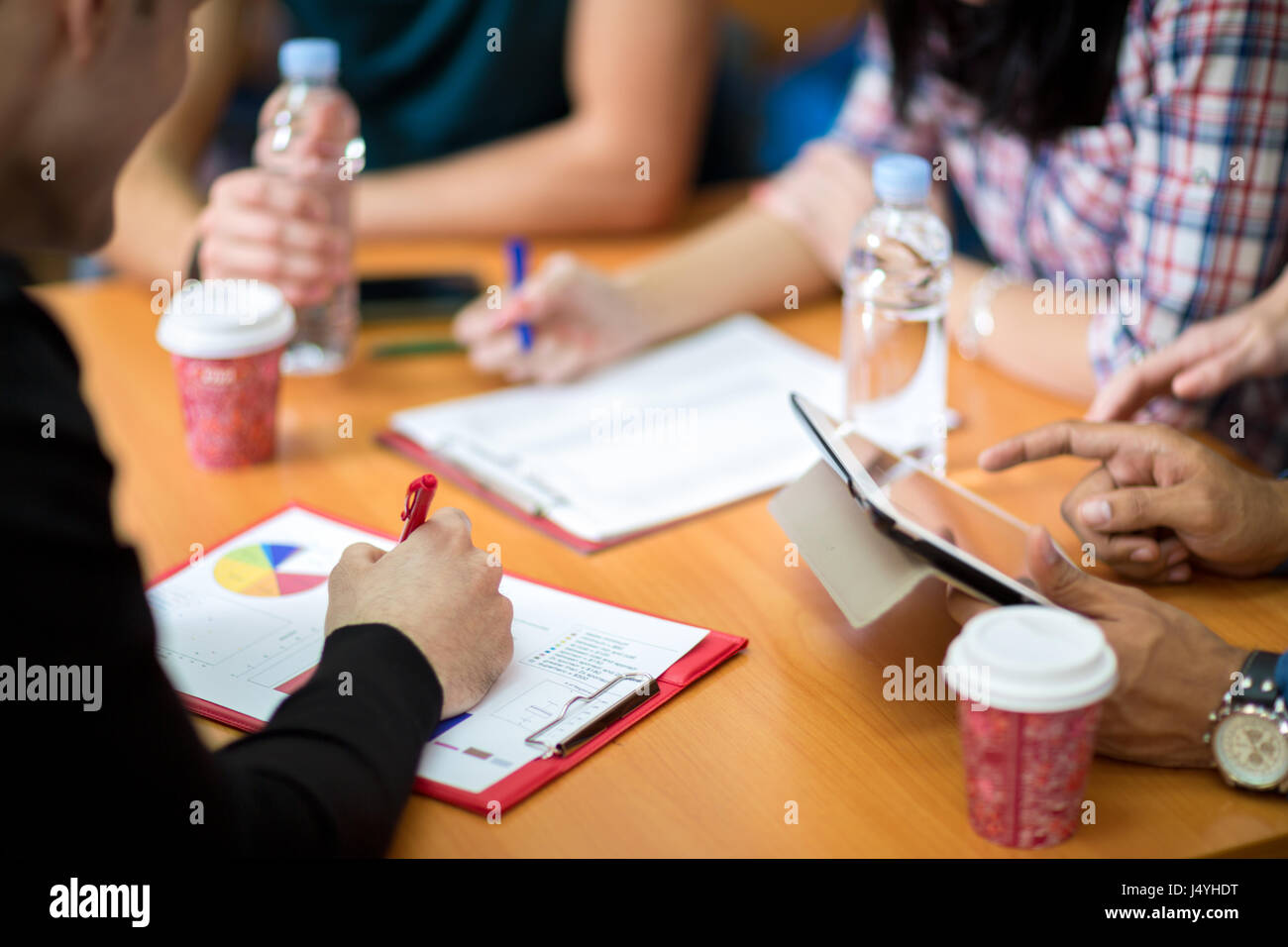 Stretta di mano con le scartoffie e tablet sul tavolo di lavoro Foto Stock