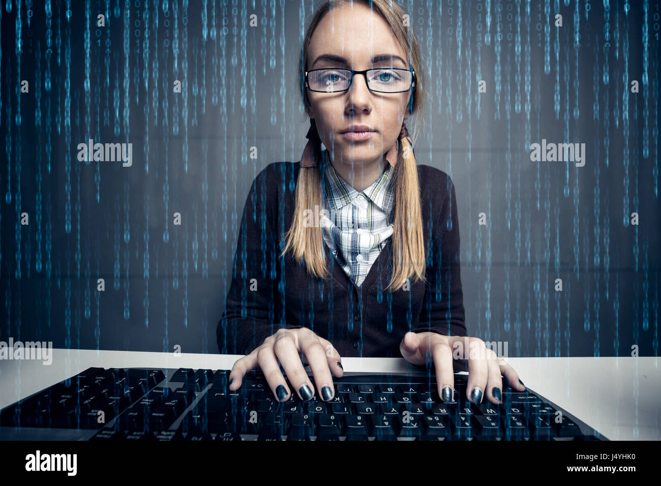 Nerd ragazza utilizzando un computer con codice binario sullo schermo Foto Stock