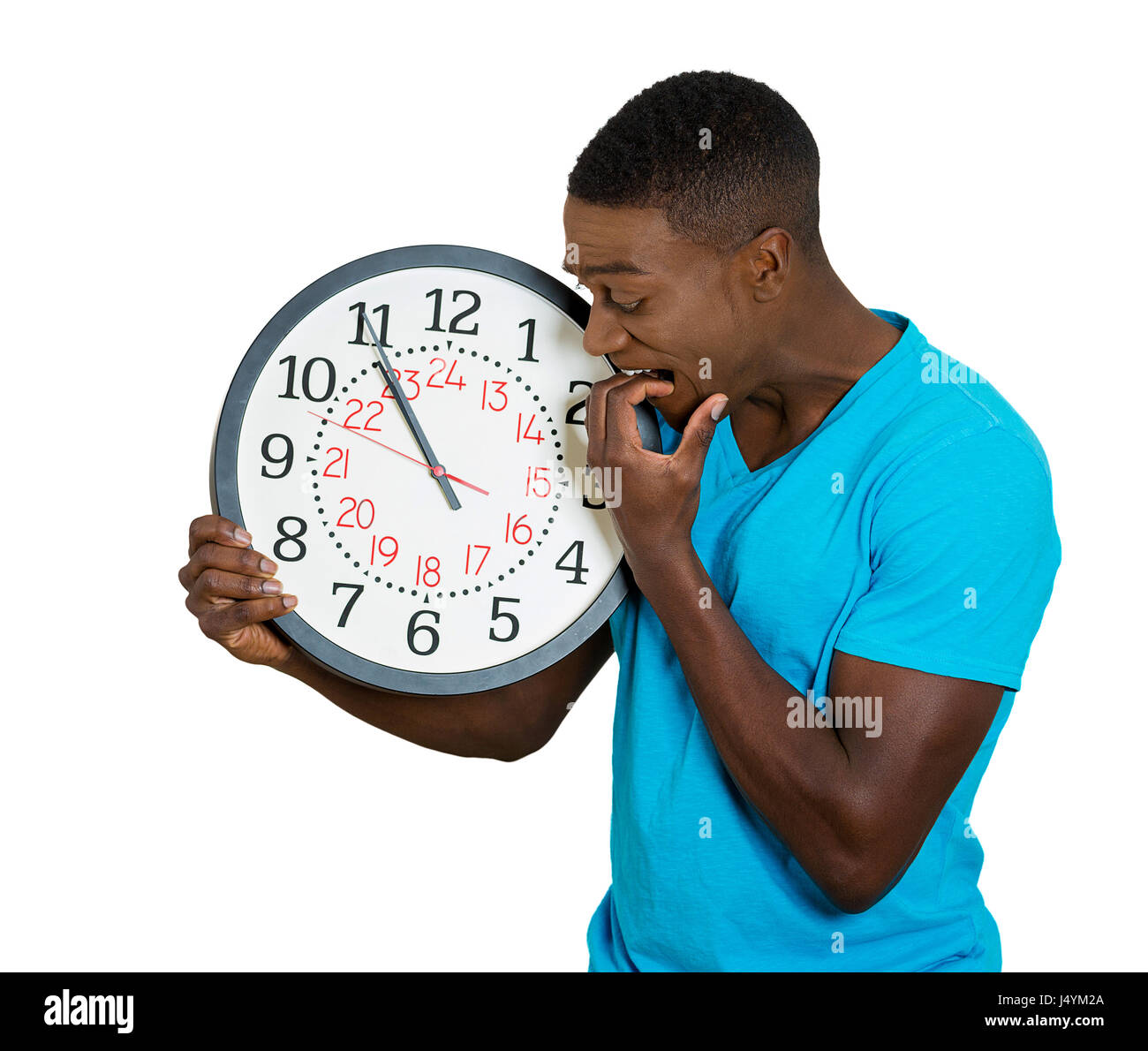 Closeup ritratto simpatiche uomo studente azienda orologio da parete, ha sottolineato mordere le unghie spinti dalla mancanza, in esecuzione fuori del tempo, ritardo, inter Foto Stock