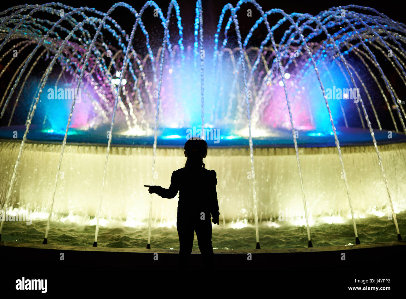 Bambino gioca con fontana colorata al parco di Lima in Perù Foto Stock