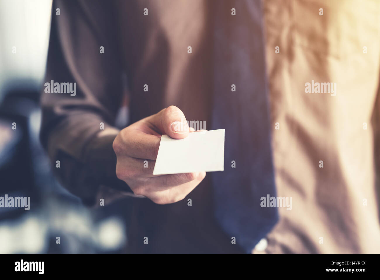 Business man holding white business card in ufficio. Vintage tonica. Foto Stock