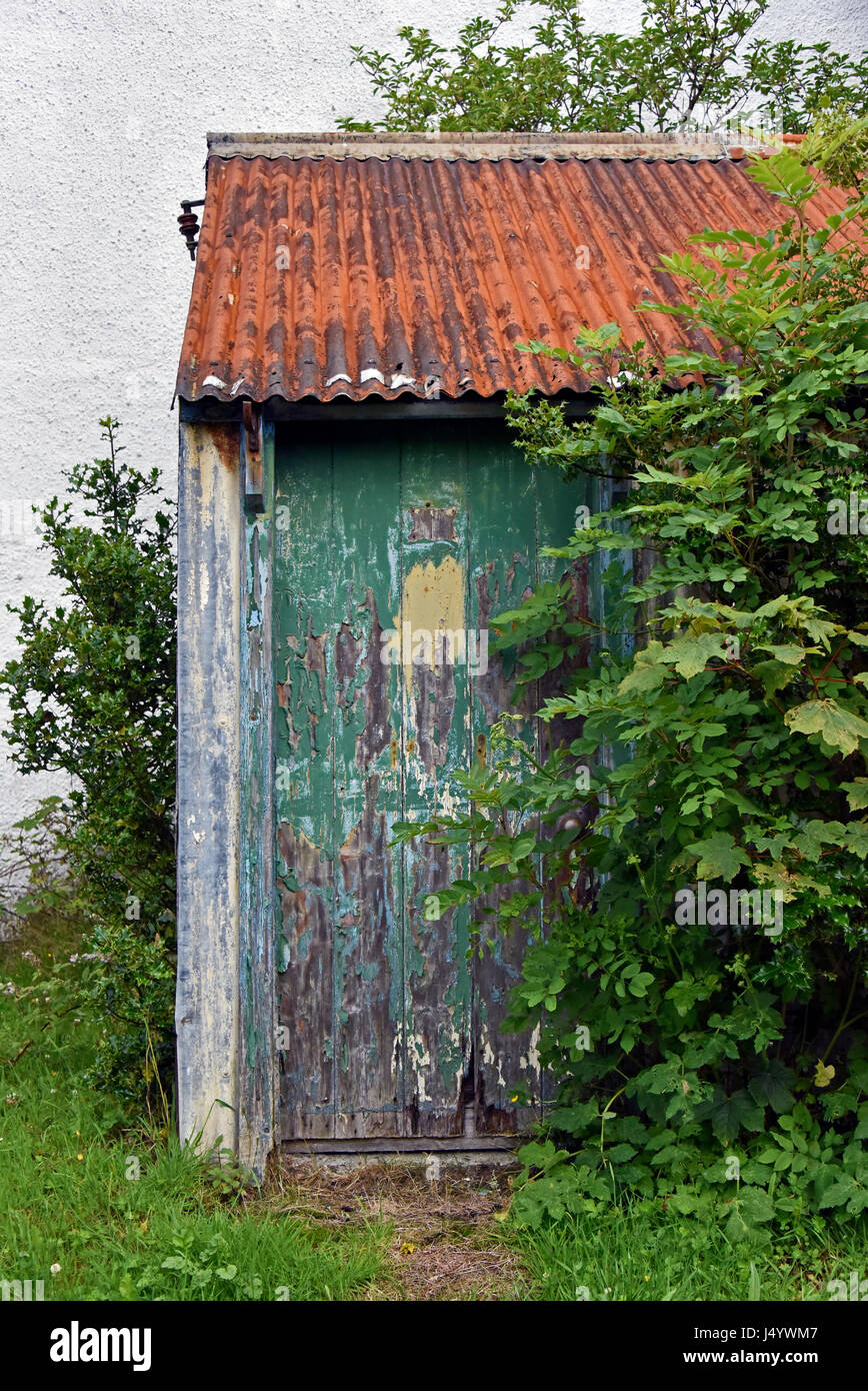 Sportello Verde su capannone abbandonato. Plockton, Ross and Cromarty, Scotland, Regno Unito, Europa. Foto Stock