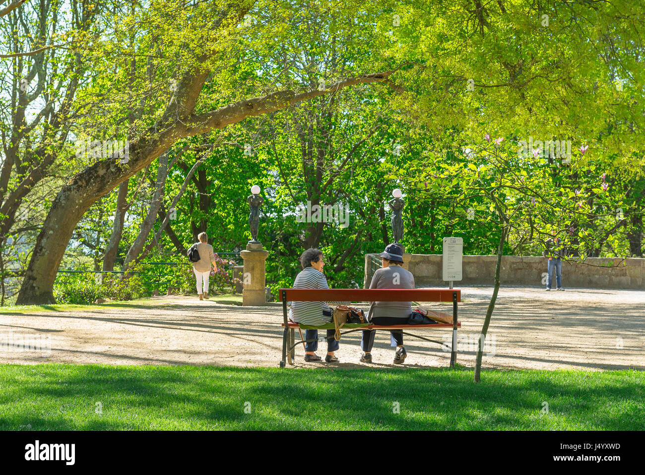 Le donne parlano da banco, due donne anziane chat su una panchina nel parco in Jardins do Palacio Cristal giardini nel centro di Porto, Portogallo. Foto Stock