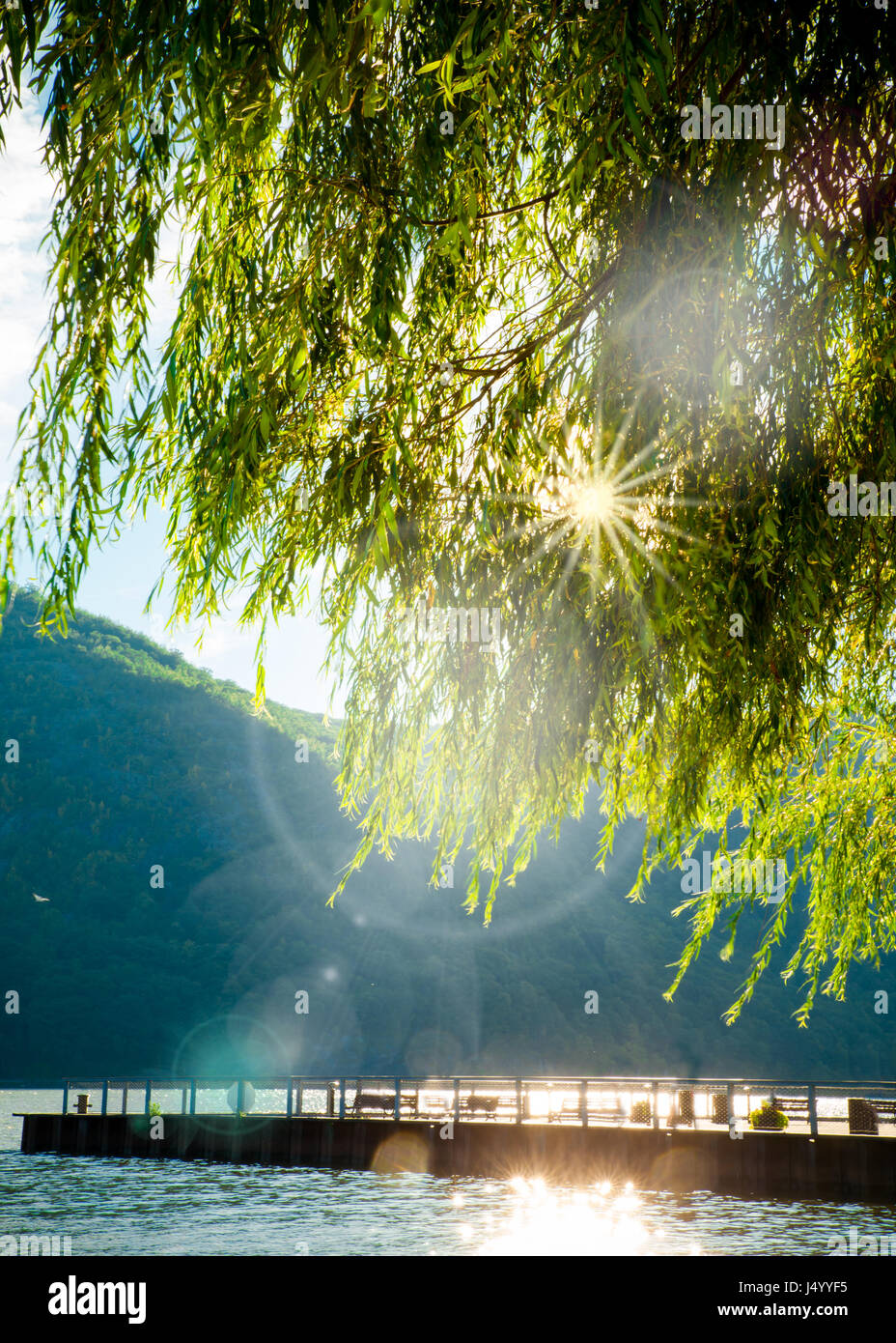 Fiume, montagne e dock con sole che splende attraverso gli alberi dal Cold Spring NY Foto Stock