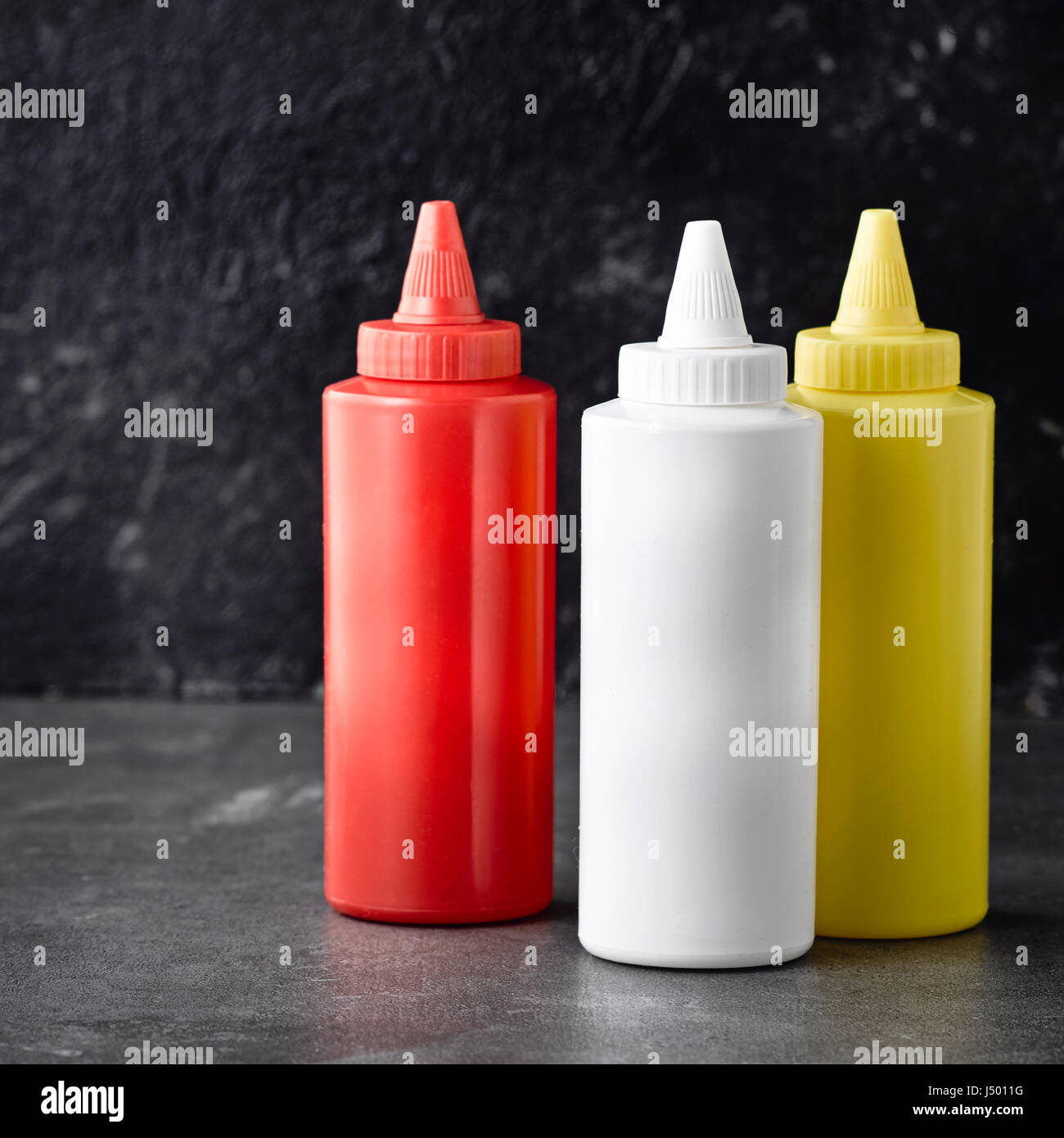 Schiacciare bottiglie di ketchup, maionese e senape Foto Stock