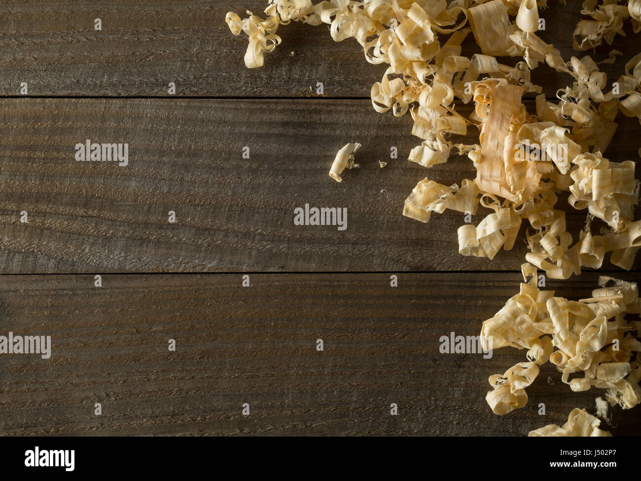 Marrone chiaro dei trucioli di legno da falegname Pialla a mano o lavoro di cesello su assi di legno con uno sfondo con spazio di copia Foto Stock
