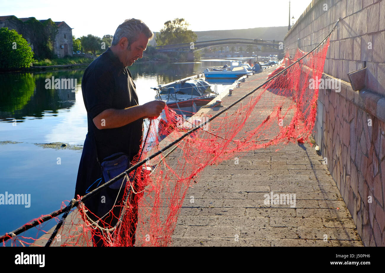 Fisherman riparazione net, Fiume Temo, Bosa, Sardegna, Italia Foto Stock