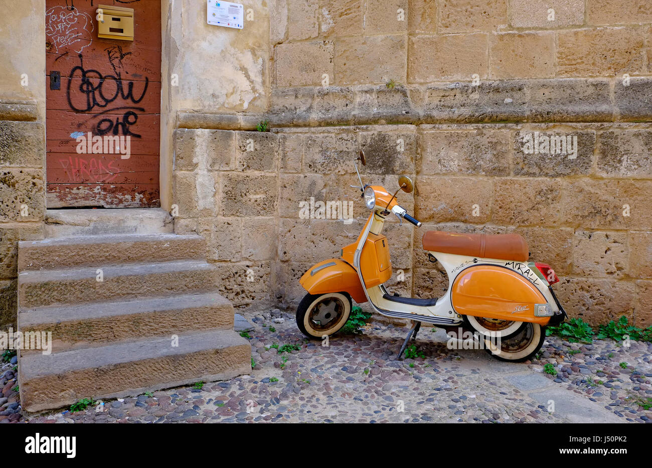 Italian scooter parcheggiato al di fuori del vecchio edificio esterno Foto Stock