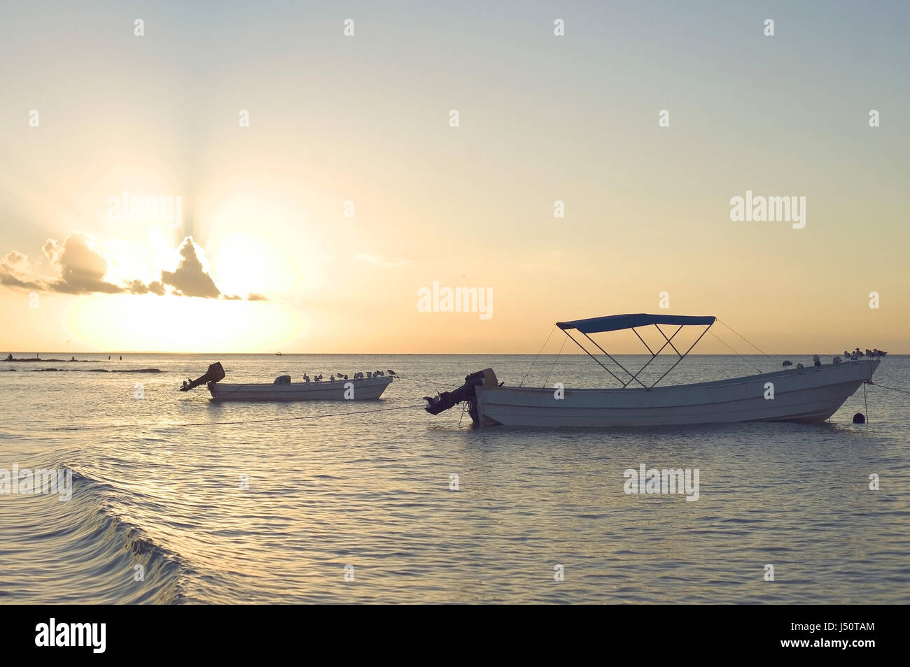 Barche con il tramonto sul mare Foto Stock