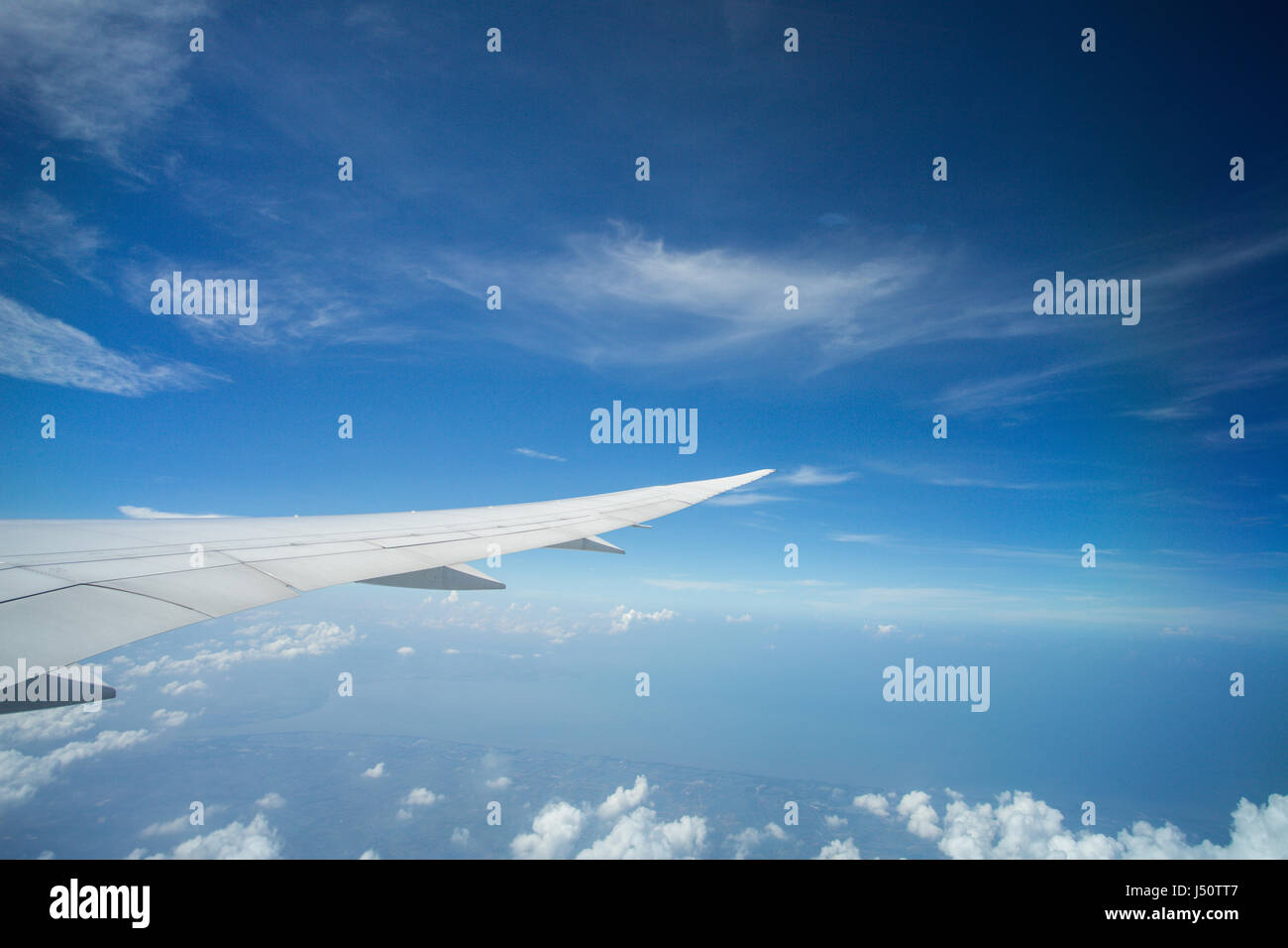 Ala di un aeroplano che vola sopra le nuvole Foto Stock