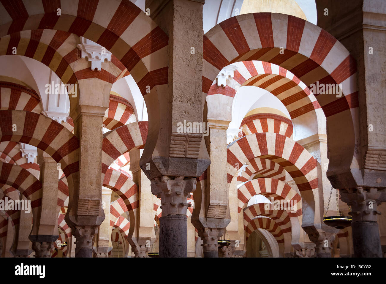 Il bianco e il rosso archi in moschea-cattedrale di Cordoba in Andalusia Foto Stock