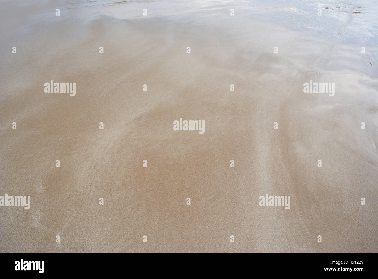 Liscio, calming patterns di acqua che fluisce attraverso la sabbia bagnata a Blowhole Beach, Deep Creek Conservation Park, Sud Australia Foto Stock