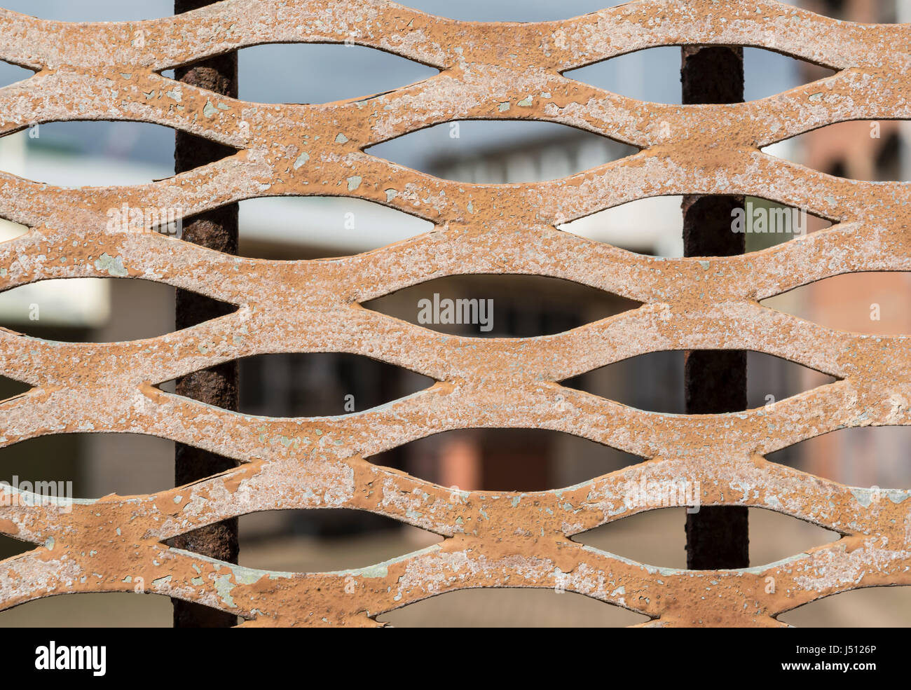 Vista astratta, guardando attraverso un peeling, arrugginendo vecchio porta di metallo griglia. Foto Stock