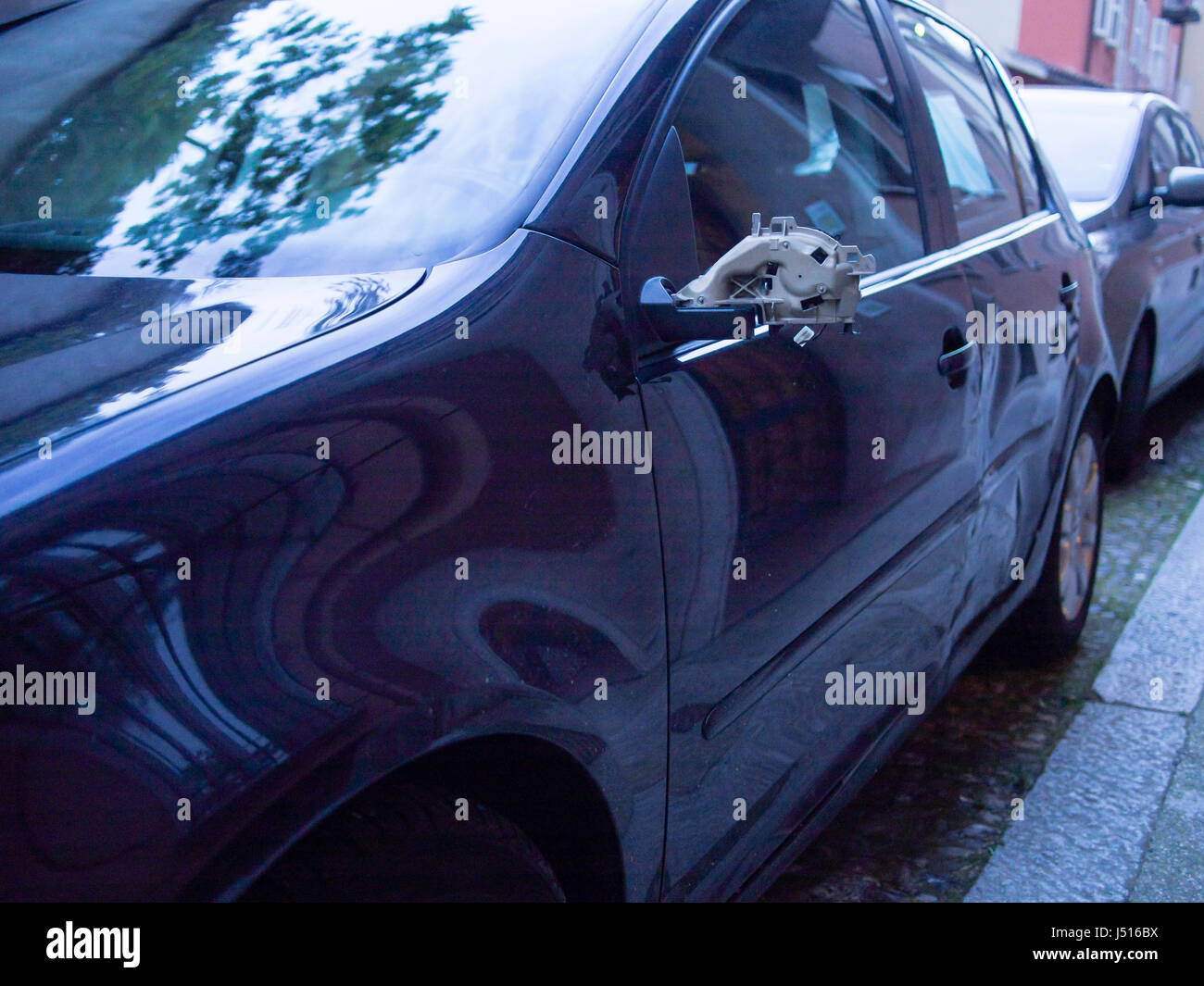 Auto con specchio rotto parcheggiato in strada Foto Stock
