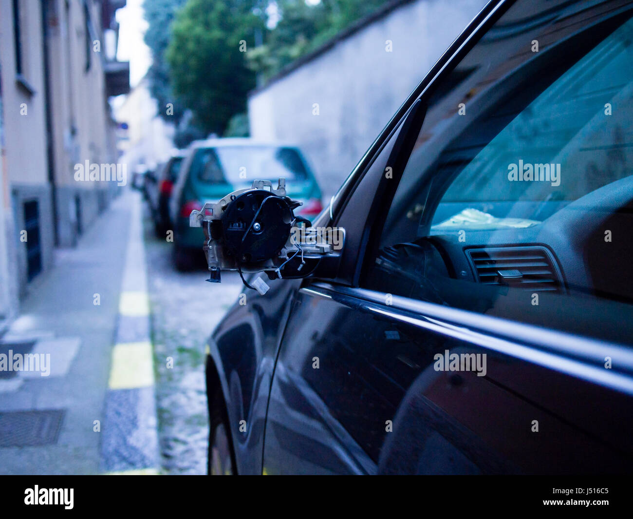 Auto con specchio rotto parcheggiato in strada Foto Stock