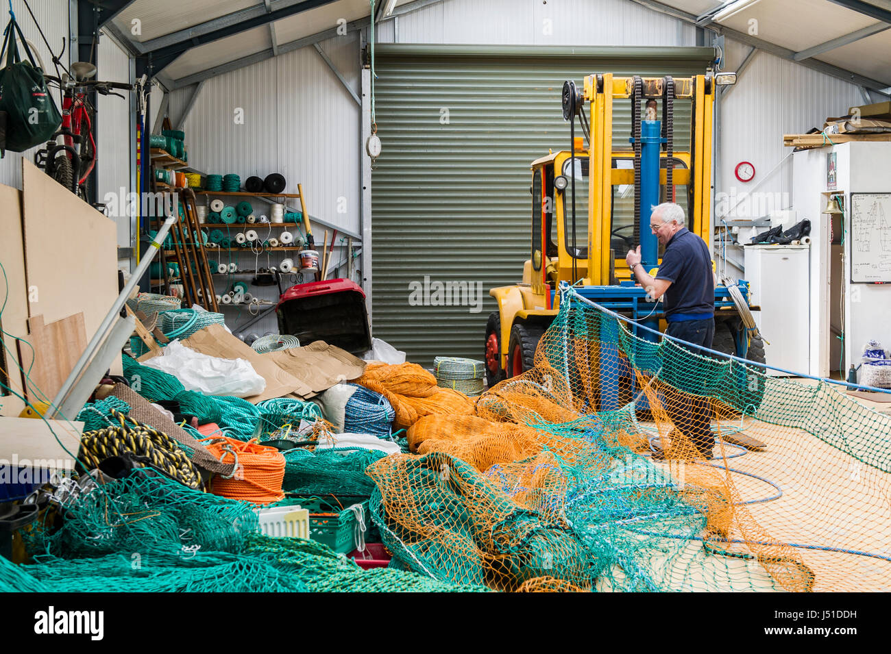 Rete da pesca maker fa un commerciale netto di pesca per un peschereccio da traino nel suo capannone in Irlanda con copia spazio. Foto Stock