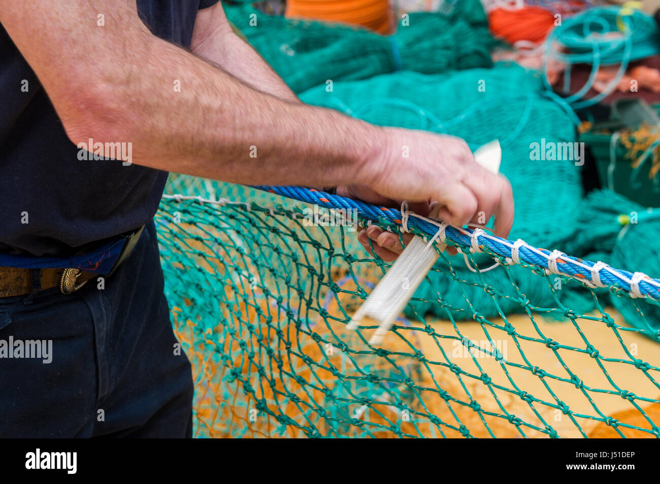 Rete da pesca maker dimostra la sua imbarcazione nel suo capannone in Irlanda con copia spazio. Foto Stock