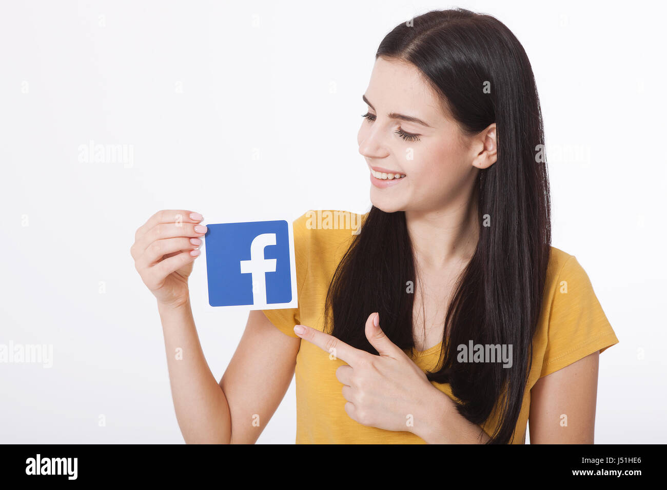 KIEV, UCRAINA - 22 agosto 2016: Donna mani tenendo l'icona Facebook segno stampato su carta su sfondo bianco. Facebook è ben noto servizio di social networking. Foto Stock