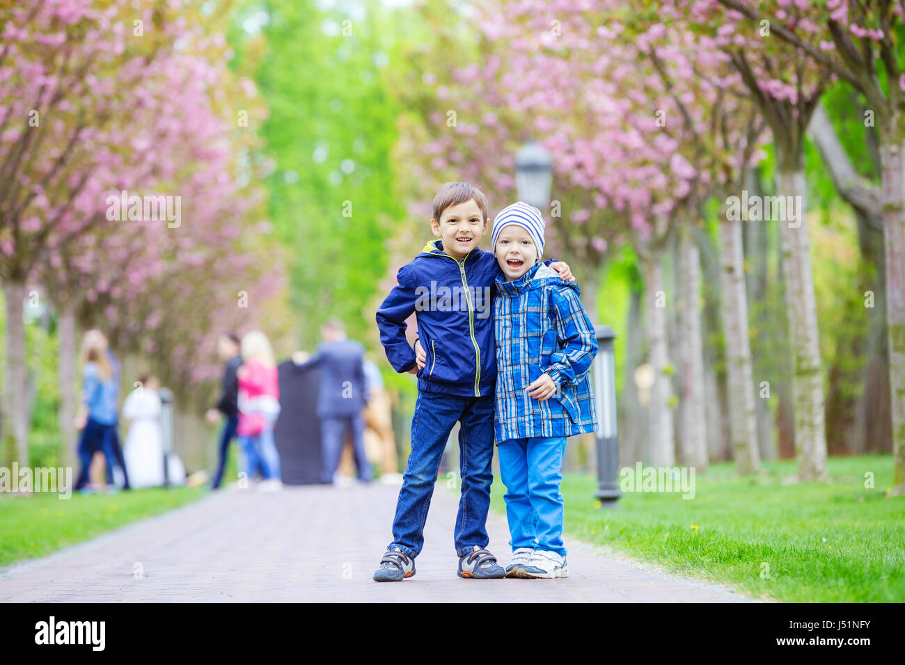 I ragazzi sorridere mentre permanente sulla corsia nel Parco di primavera Foto Stock