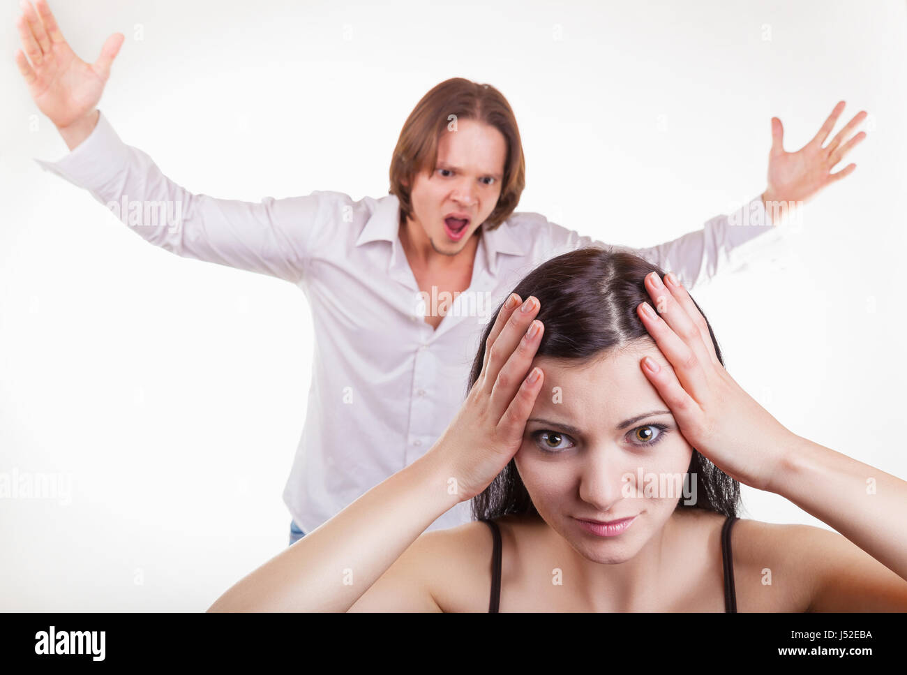 Furious, il marito grida a sua moglie, su uno sfondo bianco. Focus sulla ragazza Foto Stock