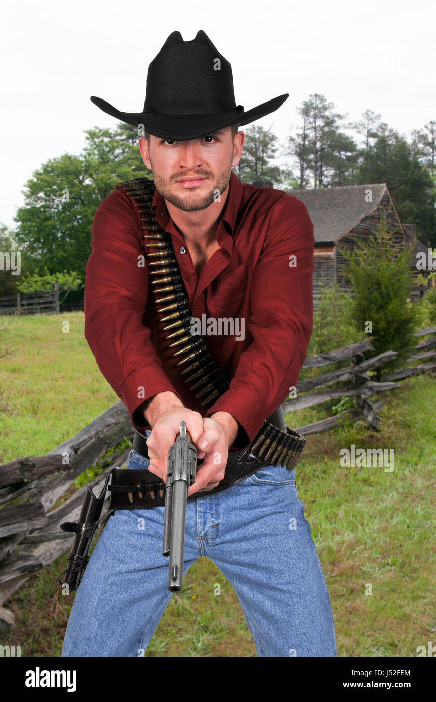 Bello cowboy uomo con sei pistole sparatutto Foto Stock