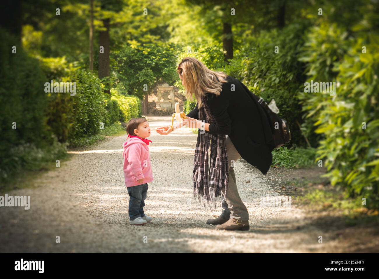 Pulire le abitudini alimentari baby mom frutta snack banana garden park Foto Stock