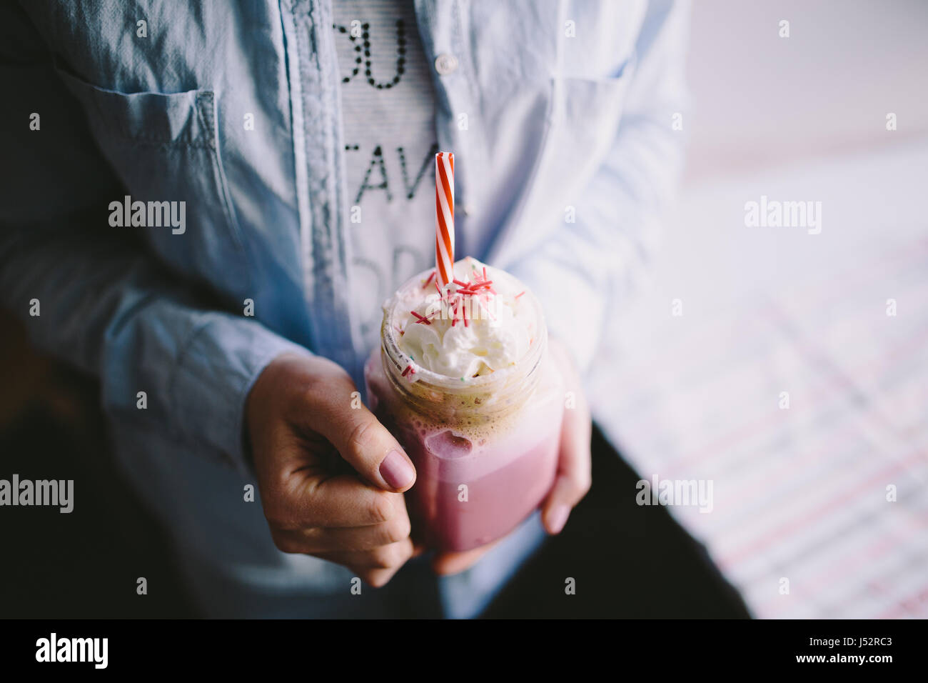 Ragazza è azienda stilizzata mason jar tazza di caffè rosa con crema, marshmallow e decorazione. Milk Shake, cocktail. Unicorn caffè, unicorn cibo. Clos Foto Stock