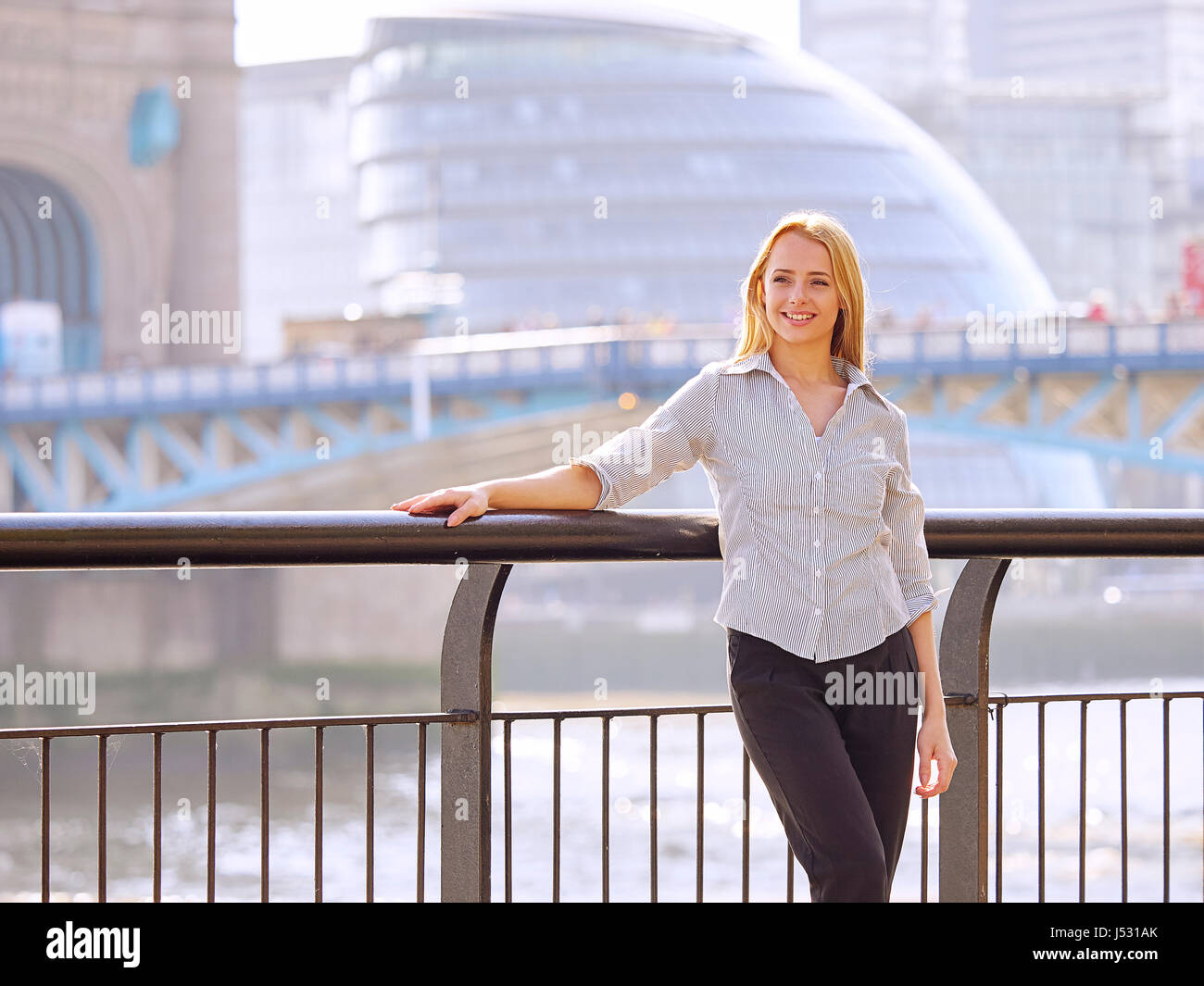 Giovane donna con il Municipio e il Tower Bridge in background Foto Stock