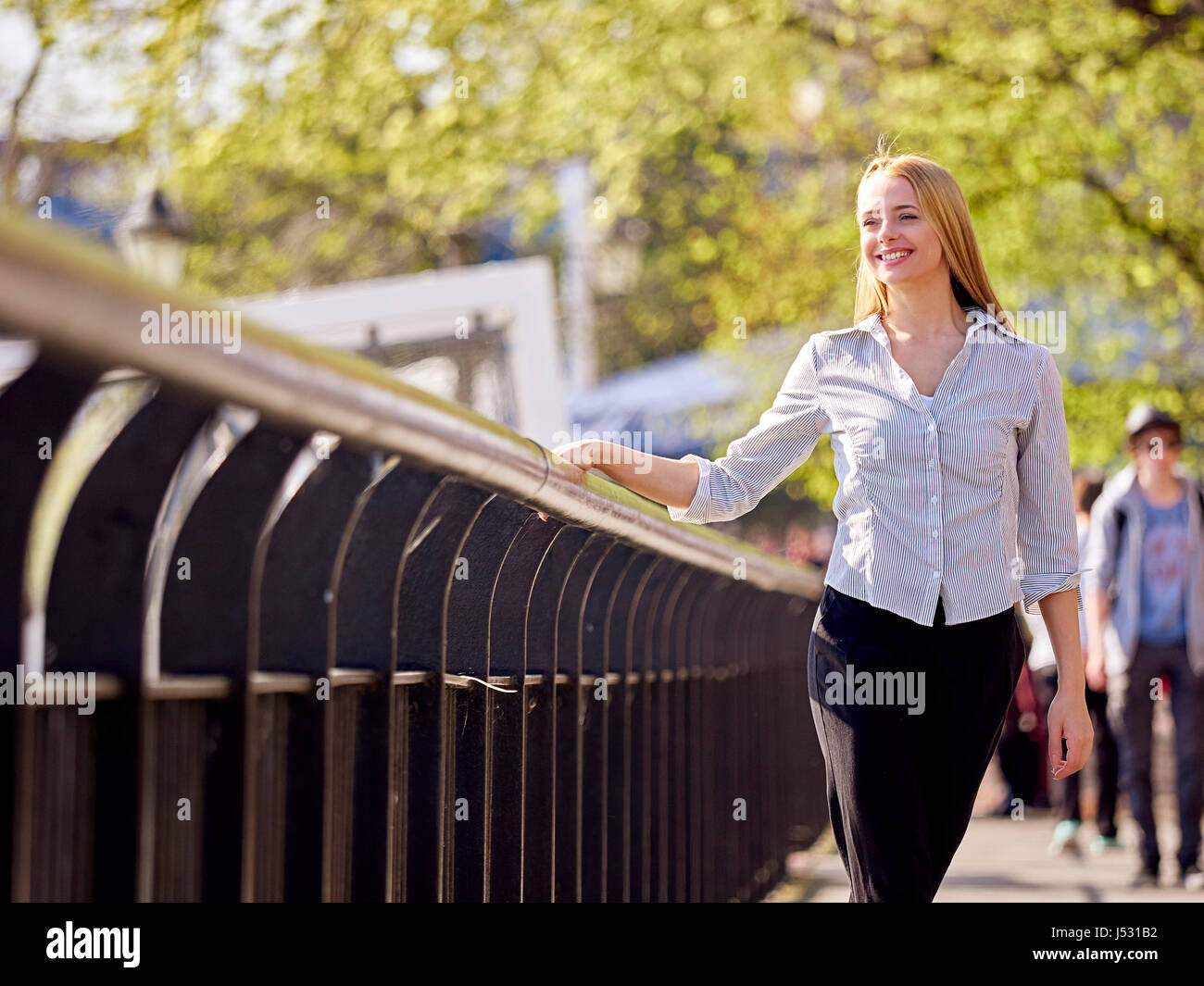 Giovane donna camminando lungo il Tamigi Foto Stock