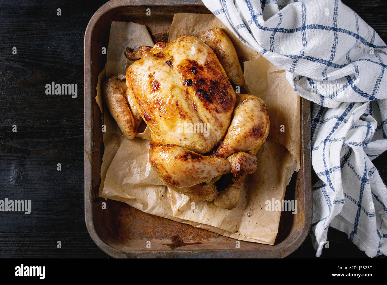 Cotta alla brace intero pollo organico sulla carta di rinforzo nel vecchio  forno vassoio con cucina