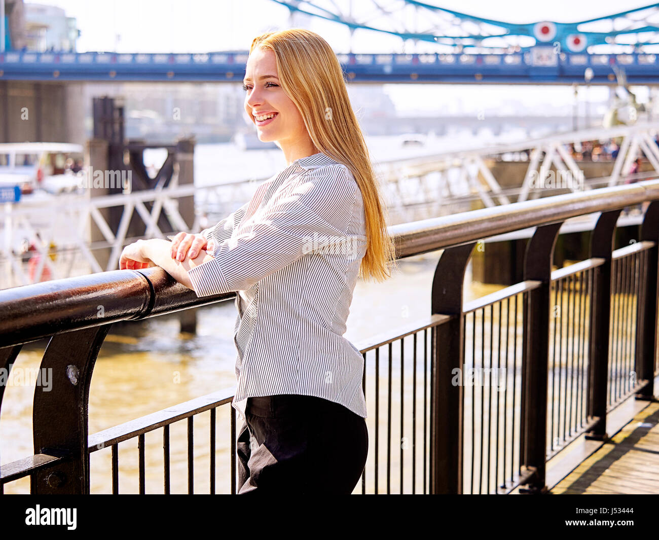 Giovane donna dal Tamigi con il Tower Bridge in background Foto Stock