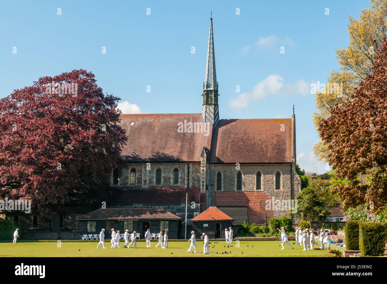 I giocatori di bocce in Bowling Green in Preston Park, Brighton, nella parte anteriore della chiesa di San Giovanni Evangelista. Foto Stock